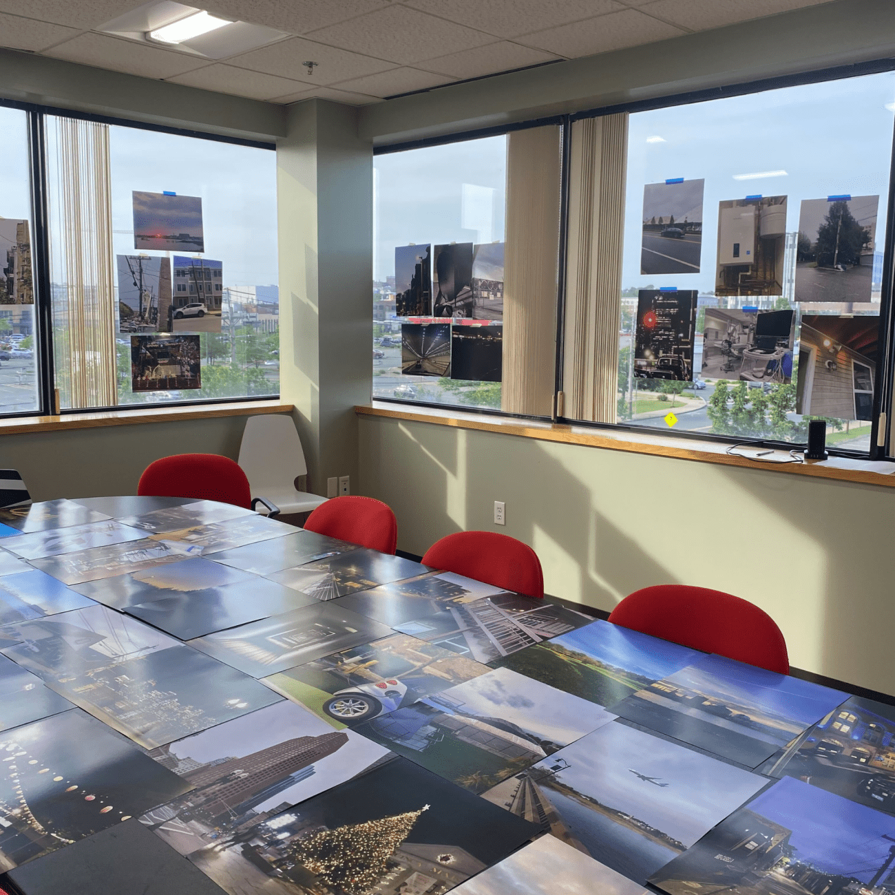 A conference table displaying several photographs arranged neatly on its surface.